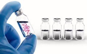 A scientist holding a vial containing mAB products. 