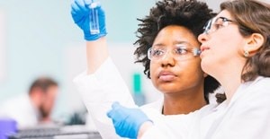 Two lab workers looking at a test tube.