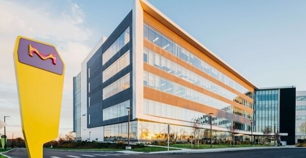 A five-story building sits on a corner with a MilliporeSigma sign off to the left. The site is in Burlington, MA, USA.