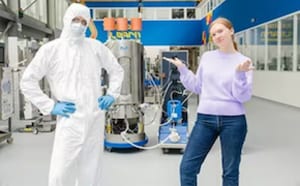 Dois cientistas, em p&eacute; em um laborat&oacute;rio, um homem com roupa de coelho, uma mulher vestindo roupas casuais