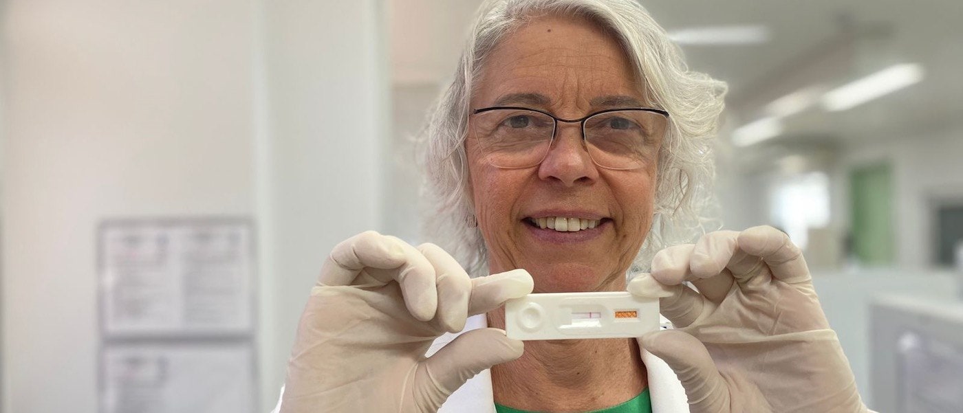 Dr. Samira Bührer wears glasses, gloves and holds up a rapid test for Hansen’s disease.   ------------ 