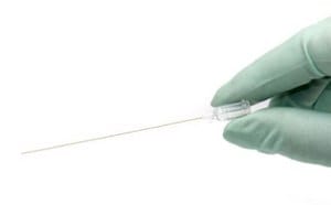 Gloved hand holding WPI MicroFil for filling micropipettes