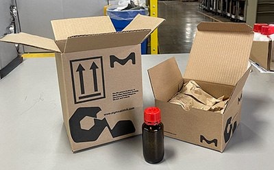 A box next to a smaller box and product bottle, demonstrating reduced packaging size and airspace for efficient shipping.