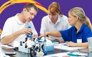 Three individuals working with laboratory equipment on a table, set against a purple background with yellow and red swirls.