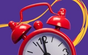 A red twin-bell alarm clock against a purple background with yellow and red swirls.