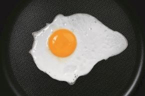 View from above of an egg on cooking on a Teflon frying pan