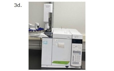 A laboratory gas chromatograph (GC) machine, specifically an Agilent Technologies 7890B model. The machine is primarily white with a digital control panel featuring a keypad and a small screen on the right side. To the left of the control panel, there is a cylindrical injection unit where samples are introduced into the machine. The top left part of the machine includes an auto-sampler with multiple blue-capped vials arranged in a circular tray. The image is labeled "3d." in the top left corner. The GC machine is placed on a lab bench against a white wall.